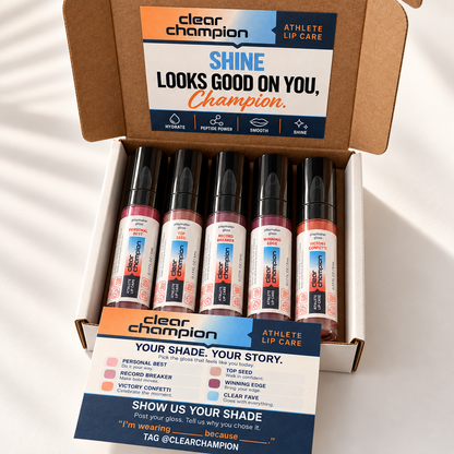 An open cardboard box of Clear Champion Athlete Lip Care lip tint tubes, with a branded insert card placed in front. The box is photographed on a white surface with soft diagonal shadows.