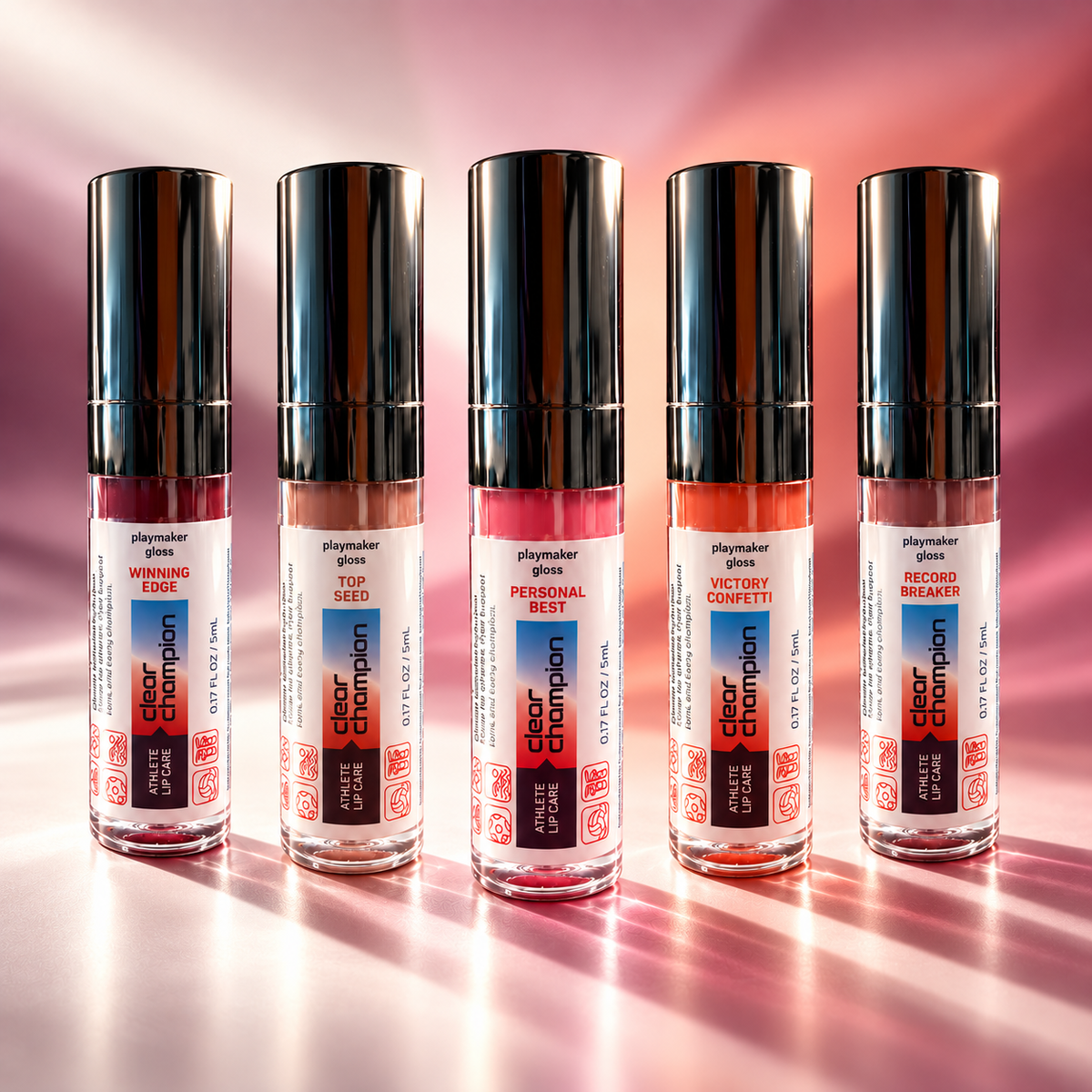 Five clear lip gloss bottles with black caps arranged in a row on a reflective pink surface. The labels show different shades and names including 'Winning Prime', 'Top Seed', 'Champion Best', 'Victory Confetti', and 'Red Carpet Breaker'.