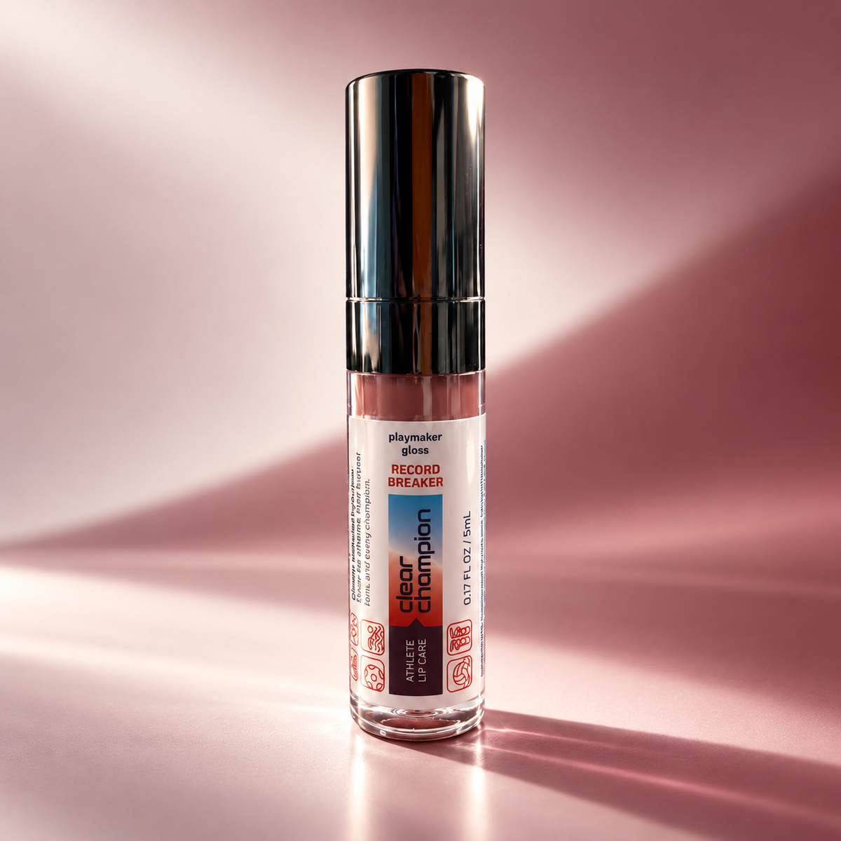A clear cylindrical gloss bottle with a reflective silver cap, standing upright on a pink studio surface. The front label reads 'shaymaker gloss' and 'Record Breaker Clear Champion'.